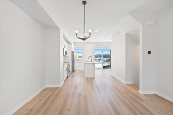 A spacious room with wooden floors and a large window.